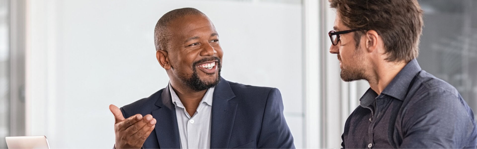A CareerJoy coach smiles as he advises a male client in an office