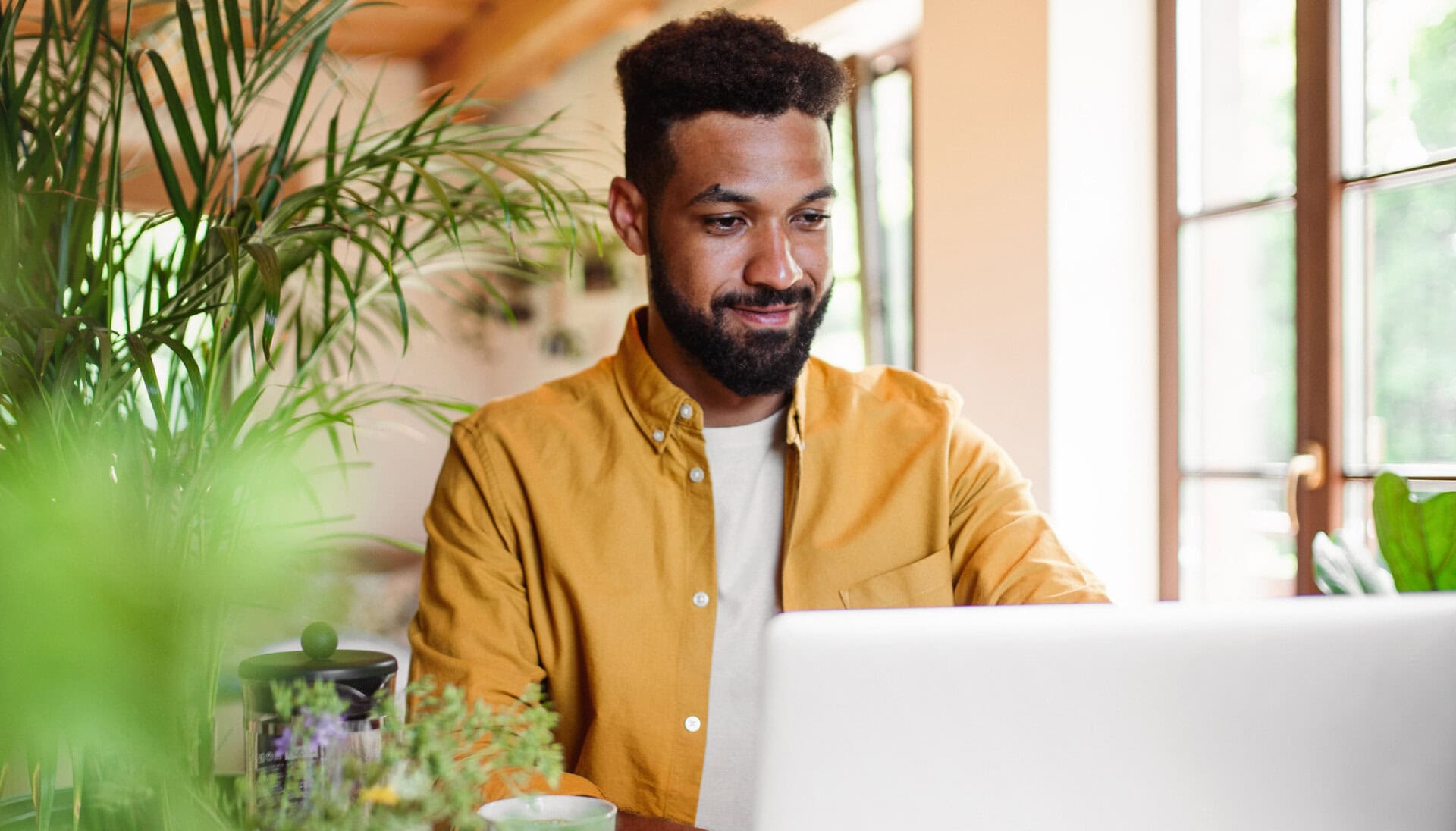Man on laptop receiving career coaching and job search support as part of outplacement services