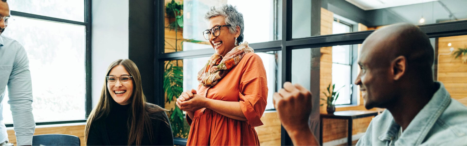 A diversity of employees laughs in a Canadian office boardroom