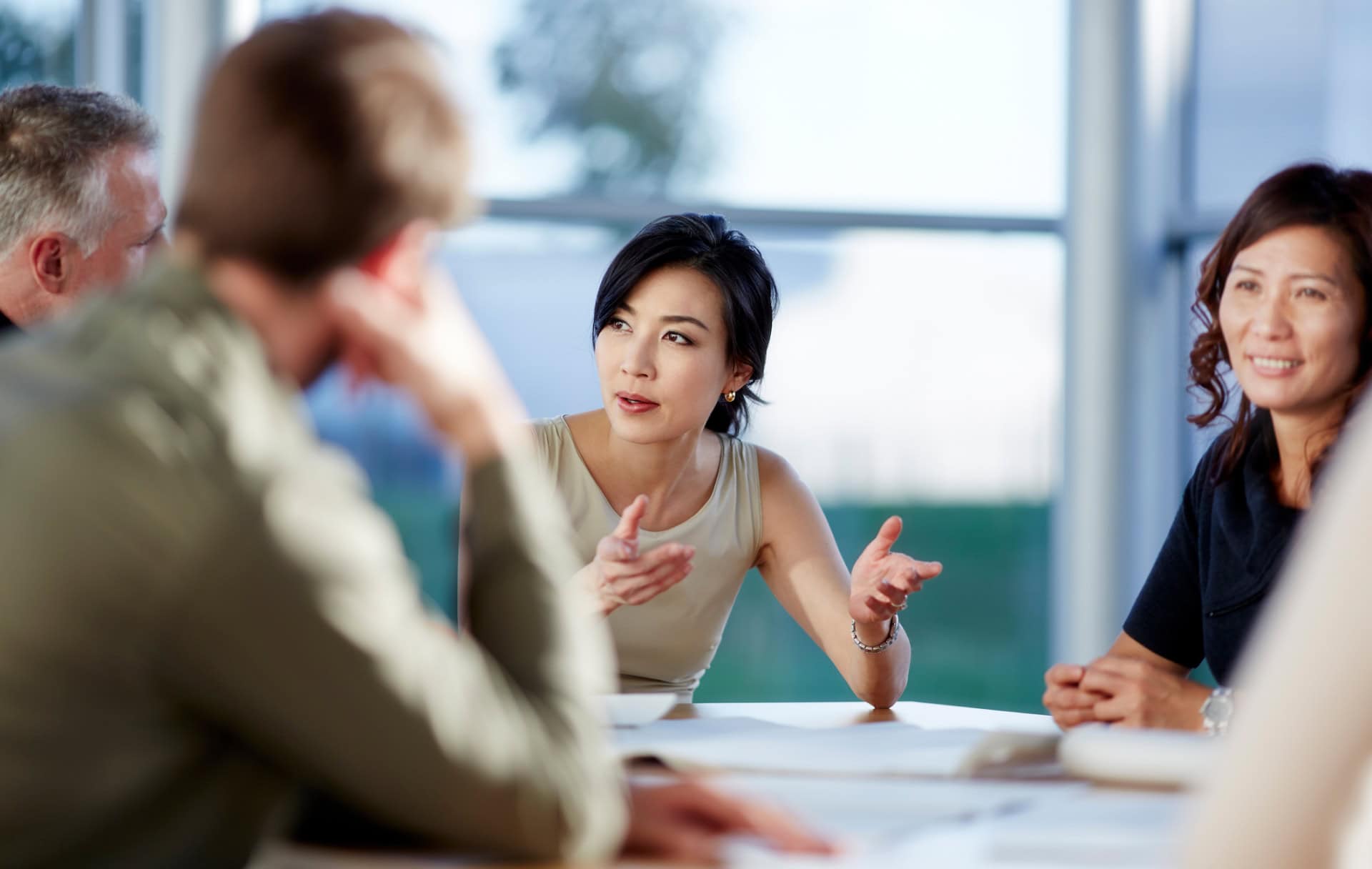 A group of employees have a discussion around a table