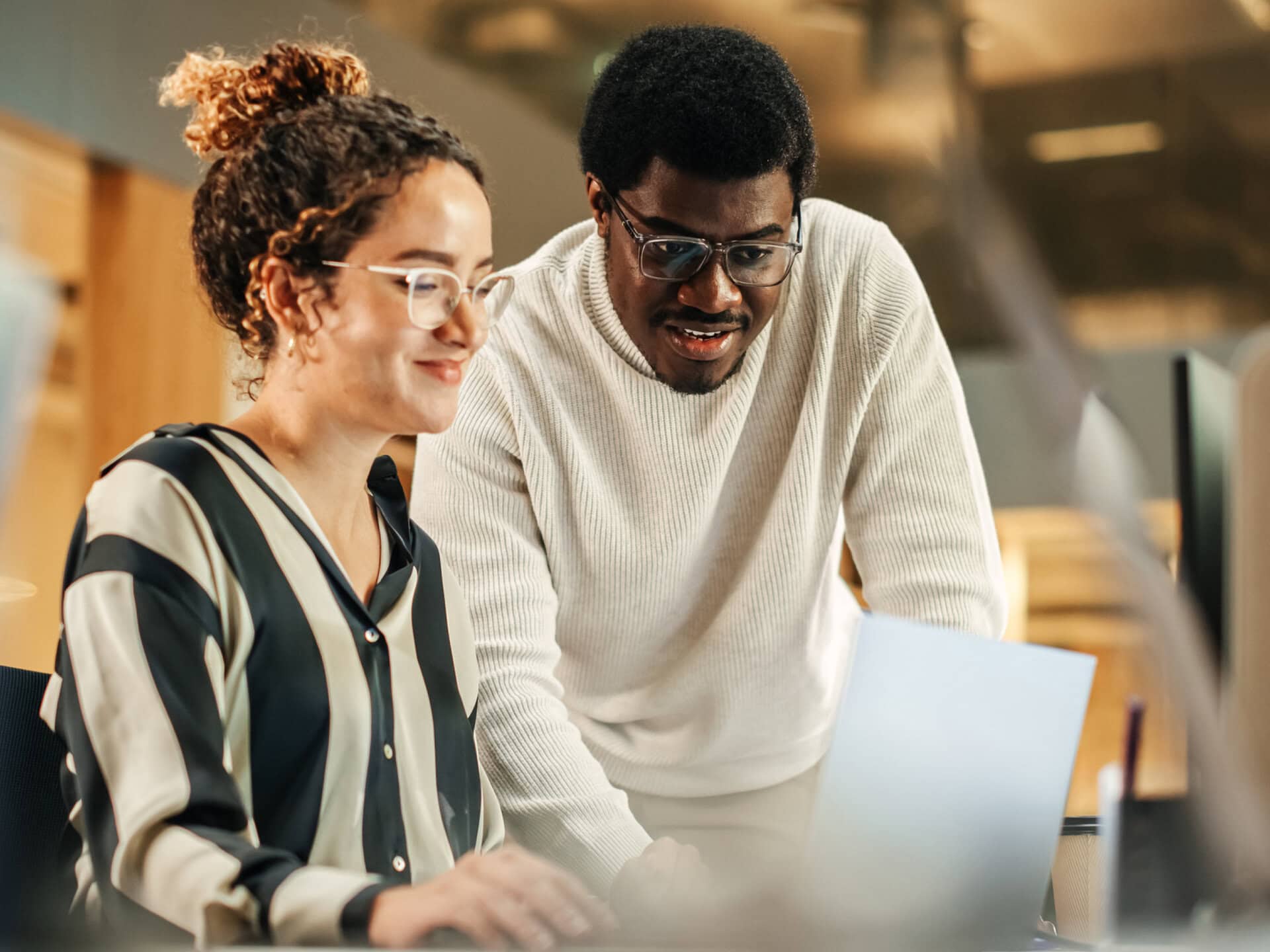 A CareerJoy coach leans over a laptop with an employee to go over results